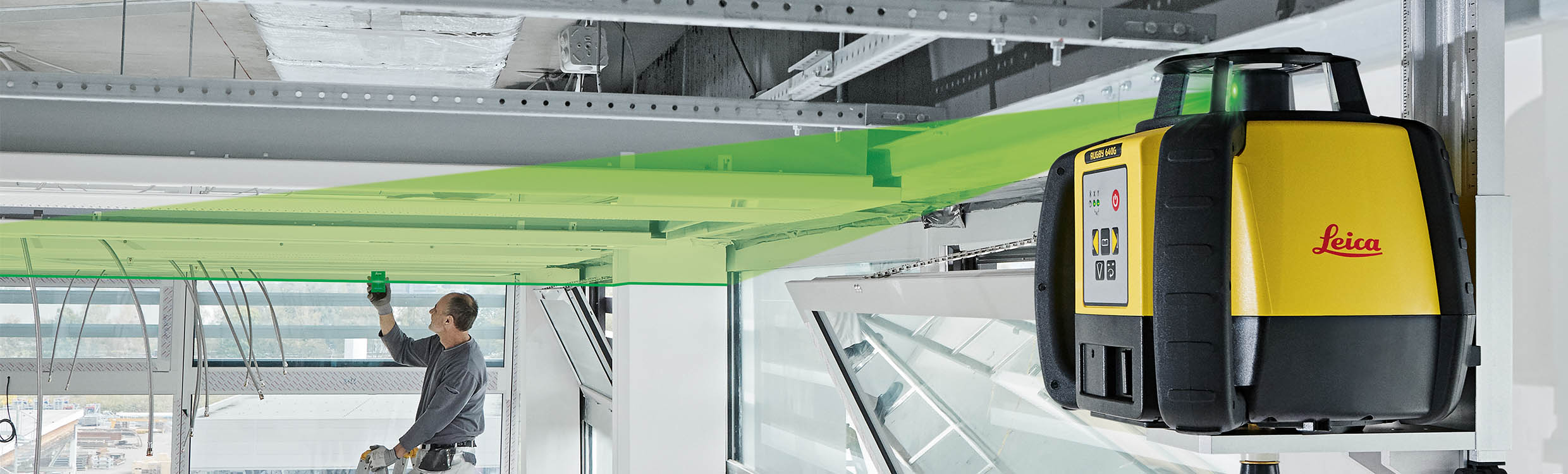 Leica Rugby 640G con raggio laser verde visibile durante il montaggio di un controsoffitto